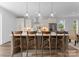 Modern kitchen with an island, breakfast bar, wooden stools, stainless steel appliances, and pendant lighting at 209 Keswick Ave, Charlotte, NC 28206