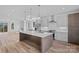 Open concept kitchen with modern lighting, stainless appliances, and exterior views at 209 Keswick Ave, Charlotte, NC 28206