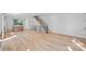 Bright, open-concept space with wood floors, modern staircase, and kitchen in the background at 209 Keswick Ave, Charlotte, NC 28206