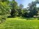 Lush backyard with mature trees and a shed, offering privacy and storage at 2104 Farmbrook Dr, Statesville, NC 28625