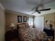 Bedroom featuring ceiling fan, two windows, closet and floral patterned bedding at 2104 Farmbrook Dr, Statesville, NC 28625
