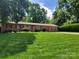 Charming brick ranch home featuring a lush lawn and mature trees in a desirable neighborhood at 2104 Farmbrook Dr, Statesville, NC 28625