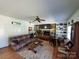 Cozy living room featuring a stone fireplace, built-in shelving, hardwood floors, and a ceiling fan at 2104 Farmbrook Dr, Statesville, NC 28625
