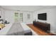 Bright bedroom with hardwood floors, large windows, and a stylish TV console at 218 Water Oak Dr, Pineville, NC 28134