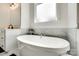 Bright bathroom with a free-standing white soaking tub situated under a window at 2324 Loire Valley Dr, Indian Land, SC 29707