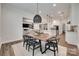 Dining area with wooden table, six chairs, and a view into the kitchen and living room with a fireplace and TV at 2324 Loire Valley Dr, Indian Land, SC 29707