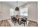 Dining room featuring a wooden table, black chairs, a woven light fixture, and natural light from two windows at 2324 Loire Valley Dr, Indian Land, SC 29707
