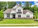 Charming two-story home featuring a manicured lawn, stone accents, and welcoming front porch at 2324 Loire Valley Dr, Indian Land, SC 29707