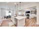Bright kitchen with white cabinets, island with seating, and open floor plan to living room with fireplace and dining room at 2324 Loire Valley Dr, Indian Land, SC 29707