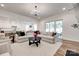Open concept living room featuring two sofas, a black round table, and an open view to kitchen and dining areas at 2324 Loire Valley Dr, Indian Land, SC 29707