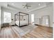 Elegant main bedroom featuring a four-poster bed, tray ceiling, and neutral decor with lots of natural light at 2324 Loire Valley Dr, Indian Land, SC 29707