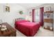 Cozy bedroom featuring a red comforter, wood dresser, and natural light at 2399 Ashbourne Se Pl, Concord, NC 28025