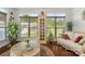 Inviting living room with natural lighting from many windows, wicker furniture, and hardwood floors at 2399 Ashbourne Se Pl, Concord, NC 28025