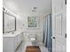 This bathroom features white cabinets, a marble countertop, and a shower/tub combo at 2432 Hartmill Ct, Charlotte, NC 28226