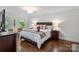 This primary bedroom offers beautiful hardwood floors, a Queen bed, and neutral paint at 2432 Hartmill Ct, Charlotte, NC 28226
