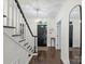 Welcoming foyer showcasing hardwood floors, staircase with black accents, and a striking entrance door at 2432 Hartmill Ct, Charlotte, NC 28226