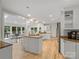 Bright eat-in kitchen features white cabinets, granite countertops, an island and hardwood floors at 2432 Hartmill Ct, Charlotte, NC 28226