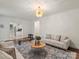 Open living room area featuring hardwood floors, modern light fixture, and comfortable seating at 2432 Hartmill Ct, Charlotte, NC 28226
