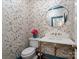 Stylish powder room with floral wallpaper, a marble sink, and a gold-framed mirror at 2432 Hartmill Ct, Charlotte, NC 28226