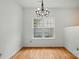 Cozy dining area with a window view, a modern light fixture and hardwood floors at 2723 Craddock Ave, Charlotte, NC 28208
