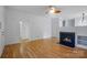 Living room featuring hardwood floors, a cozy fireplace, a ceiling fan, and neutral walls at 2723 Craddock Ave, Charlotte, NC 28208