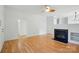 Open-concept living room with hardwood floors, ceiling fan, and modern fireplace at 2723 Craddock Ave, Charlotte, NC 28208