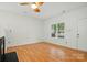 Bright living room with hardwood floors, ceiling fan, and natural light from a large window at 2723 Craddock Ave, Charlotte, NC 28208