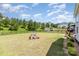 Landscaped backyard with a playground, manicured lawn, fenced perimeter, and plenty of trees at 2732 Berkhamstead Cir, Concord, NC 28027