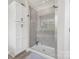 Modern shower with glass door and neutral tile complemented by white linen closet at 2732 Berkhamstead Cir, Concord, NC 28027