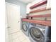 Bright laundry room with a modern washer and dryer, floating shelves, and neutral flooring at 3051 Dairy Farm Dr, Monroe, NC 28110