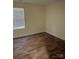 Bedroom features wood-look flooring and a neutral color palette, enhanced by natural light at 307 Wilson St, Monroe, NC 28112