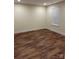 Neutral bedroom enhanced by wood-look flooring and natural light at 307 Wilson St, Monroe, NC 28112