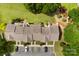 Aerial view showcases rooftops of attached homes and parking spaces landscaped with green grass and bushes at 3247 Mannington Dr, Charlotte, NC 28270