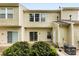 Back exterior showcasing sliding glass doors leading to patio area with established bushes and plants at 3247 Mannington Dr, Charlotte, NC 28270
