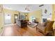 Bright living room with wood floors, a fireplace, and a view to the front door entrance at 3247 Mannington Dr, Charlotte, NC 28270