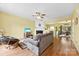 Cozy living room with fireplace, ceiling fan, and view of the open-concept kitchen and dining at 3247 Mannington Dr, Charlotte, NC 28270