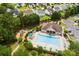 Aerial view of pool and playground featuring lounge chairs, umbrellas, a clubhouse, and walking trail at 3247 Mannington Dr, Charlotte, NC 28270