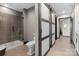 Modern bathroom featuring sliding door, tiled shower, toilet, and vanity with granite counter at 333 W Trade St # 1106, Charlotte, NC 28202