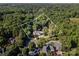 Aerial view of an estate nestled among lush greenery surrounded by mature trees at 3500 Cedar Springs Sw Dr, Concord, NC 28027