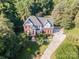 Overhead view of a brick home with mature trees, a long driveway, and an expansive lawn at 3500 Cedar Springs Sw Dr, Concord, NC 28027