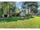Charming backyard with a fire pit, storage sheds, and mature trees at 3500 Cedar Springs Sw Dr, Concord, NC 28027