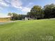 Sprawling front yard featuring a single story home with a carport surrounded by mature trees under a blue sky at 4330 Rowell Rd, Lancaster, SC 29720