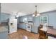 Bright kitchen with light blue cabinets, a ceiling fan, and a chandelier over the adjacent dining area offers vintage charm at 4330 Rowell Rd, Lancaster, SC 29720
