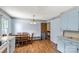 Bright kitchen with light blue cabinets, laminate flooring and an adjacent dining area provides ample space for cooking and dining at 4330 Rowell Rd, Lancaster, SC 29720
