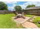 Cozy backyard fire pit area with brick patio and four chairs, perfect for outdoor entertaining at 4469 Greystone Sw Dr, Concord, NC 28027