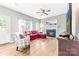 Cozy living room with a fireplace, ceiling fan, and natural light coming through multiple windows at 4469 Greystone Sw Dr, Concord, NC 28027