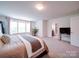 Expansive primary bedroom featuring a large window, carpet, and ensuite bathroom at 5121 Arbordale Way, Mount Holly, NC 28120