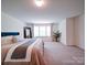 Spacious primary bedroom featuring a large window with natural light and neutral colored carpet at 5121 Arbordale Way, Mount Holly, NC 28120