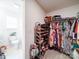 Walk-in closet with shelving for storage and view into the ensuite bathroom at 5121 Arbordale Way, Mount Holly, NC 28120