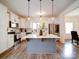 Bright kitchen boasts white cabinets, stainless steel appliances, and a large center island with pendant lighting at 5121 Arbordale Way, Mount Holly, NC 28120